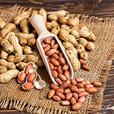 Peanuts in a scoop on a burlap surface