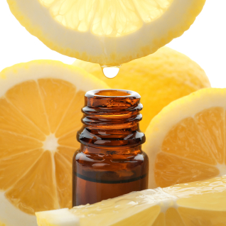 To A bottle of essential oil surrounded by lemon slices