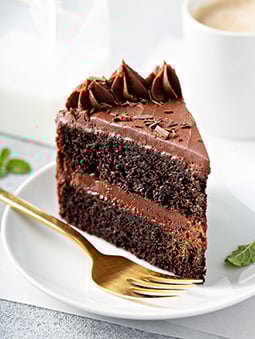 IMAGE ALT TEXT	Slice of layered chocolate cake with a gold fork