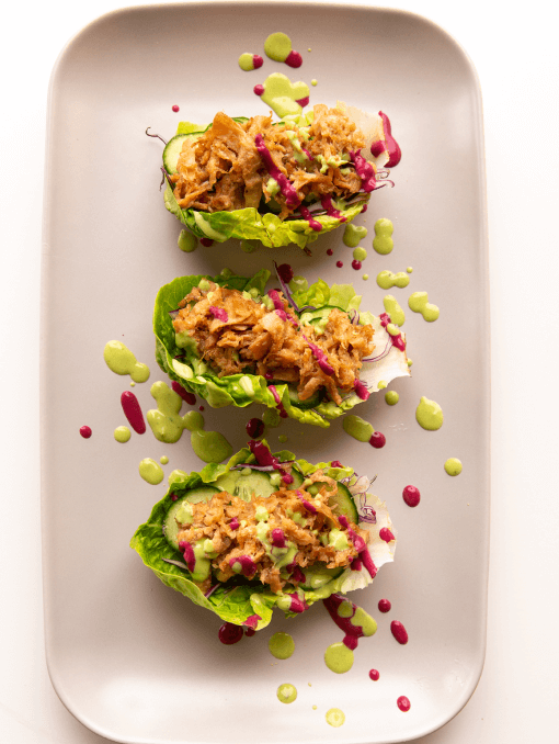 A plate of lettuce cups on a white surface